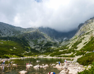 Lomica Peak, Slovakia, August 9, 2017, small pond with people closer shot.