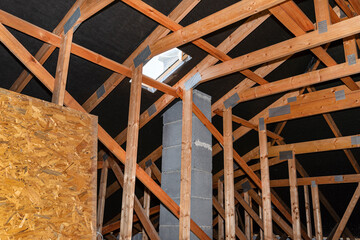 Attic with visible trusses, roof hatch for a chimney sweep and with a system chimney.