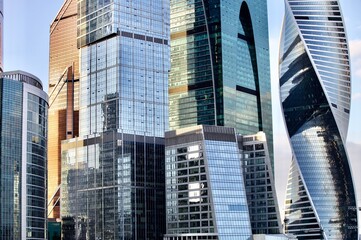 Obraz premium Office and residential skyscrapers on bright sun and clear blue sky background. Commercial real estate. Modern business city district. Office buildings exterior. Financial city district. City downtown