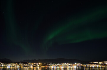 majestic aurora borealis dancing on night sky over the arctic circle city of tromsoe at dawn