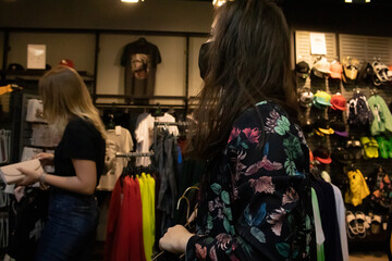 Attractive young brunette woman in yellow t-shirt and flowery shorts costume. In medical black face mask. shopping. modern reality. covid-19 concept. copy space. High quality photo