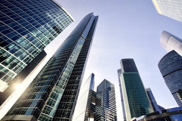 Obraz na płótnie Canvas Office and residential skyscrapers on bright sun and clear blue sky background. Commercial real estate investment. Modern business city district. Office buildings. Financial city area. Downtown.