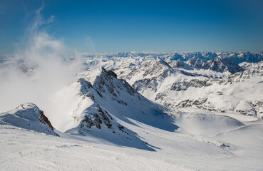 Spring alp scenery from Molltal glacier. Rocks, clouds and sun over ski slopes. Austria, Carinthia,...