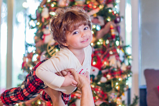 little child with Christmas tree on Christmas morning in Christmas pajamas PJ's stock photo royalty free 