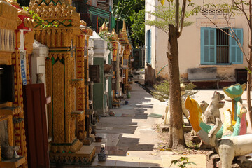 Collection of stupas and pagodas used as graves aligned along temple walls of a wat in Siamese Lao PDR, Southeast Asia