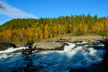 Fototapeta na wymiar majestic colorful autumn landscape with mighty roaring waterfall