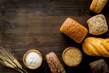 Set of different bread with wheat ear on wooden table. Top view
