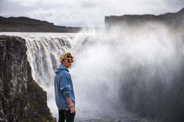 Obraz premium Hiker standing at the edge of the Dettifoss waterfall in Iceland
