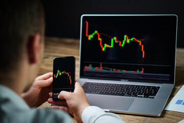 The young crypto and stock trader - investor is trying to prepare for next market collapse. Another crisis is coming and prices on the charts are falling down.