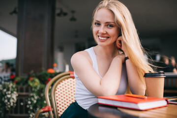 Young cheerful woman having coffee break in city