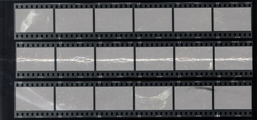 long 35mm filmstrips behind protection foil with deep scratches, cool photo placeholder.
