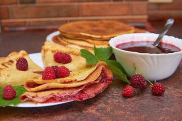 pancakes with raspberry jam,appetizing pancakes with raspberries in the kitchen