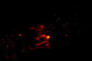Fototapeta na wymiar Bright orange fire with sparks. New year celebration. Concepts of cooking or fire event. Fire close up shot. Abstract background. 