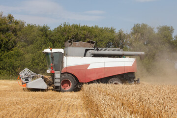 Combine harvester working in a very wide wheat field