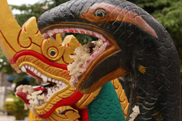 Heads of a dragon and snake image carrying rice in their mouths as traditional worshipping...