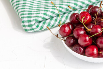 Ripe bright cherry on a white table. Close-up.