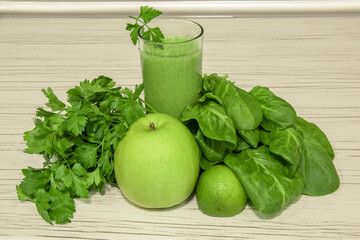 Green smoothie on light wooden background. Healthy smoothie veggies cocktail. Green vegetables and fruits.