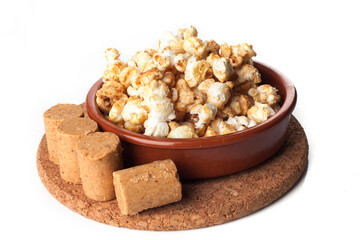 Rustic kitchen utensils with gourmet peanut candy popcorn isolated on white background.