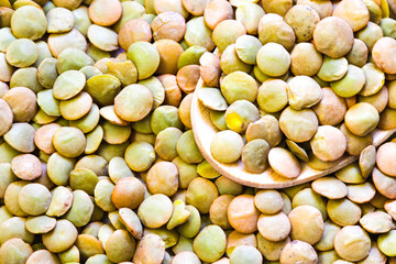 Heap of green lentil texture as background. Uncooked lentils. Top view
