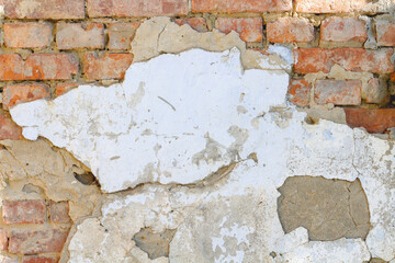 old brick wall with peeling plaster