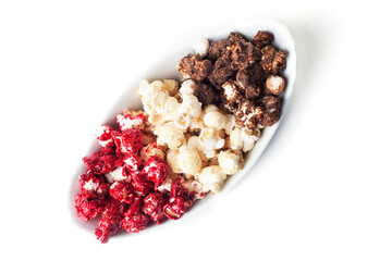 Rustic colored cups of Chocolate, Strawberry and Cream Gourmet Popcorn over white background.