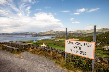 View of Allihies, in Beara Peninsula, Cork, Ireland, with a sign asking tourists to come back as soon the Covid-19 emergency is over