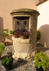 Simple European well house at the backyard. Traditional Spanish patio. 