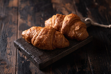 fresh croissants on a dark wooden background