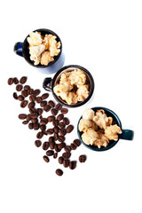 Amazing view of gourmet cinnamon and coffee popcorn with rustic utensils over a white background.