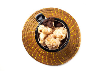 Amazing view of gourmet cinnamon and coffee popcorn with rustic utensils over a white background.