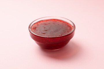 Delicious strawberry jam on pink background, close up