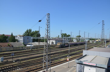 Naklejka premium railway station diesel locomotive hauling a passenger train through a railway station