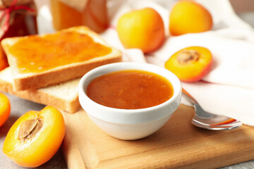 Composition with apricot jam on gray table, close up