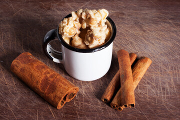 Gourmet cinnamon and coffee popcorn on wooden spoon over a wood cutting board background.
