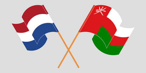 Crossed and waving flags of Oman and the Netherlands