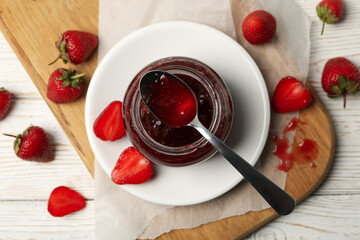 Composition with strawberry jam on white wooden background, top view