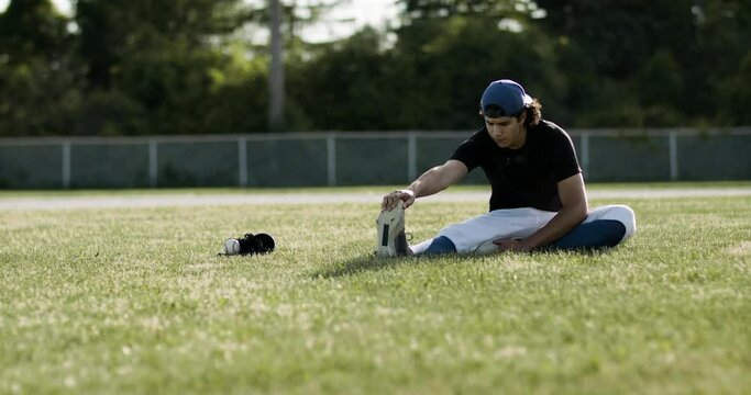 Athlete stretching and getting ready to compete. Baseball player warming up on the field before a game. Shot in 4k.