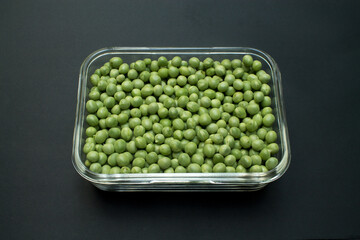 Peas in bowl on a black background.