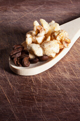 Gourmet cinnamon and coffee popcorn on wooden spoon over a wood cutting board background.