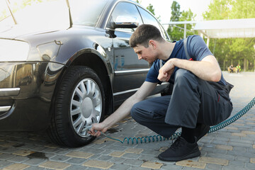 Man pumps up tires. Car inspection. Maintenance