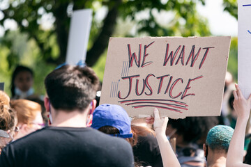 Rear view of woman holding We Want Justice sign