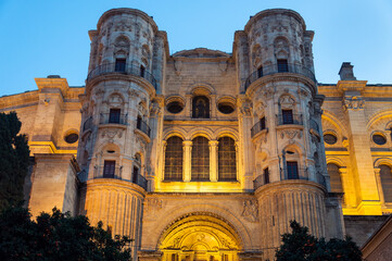 Fototapeta premium Cathedral of Malaga with night yellow illuminating lights in Malaga, Spain. Old architecture in Andalusia on Plaza del Obispo. 