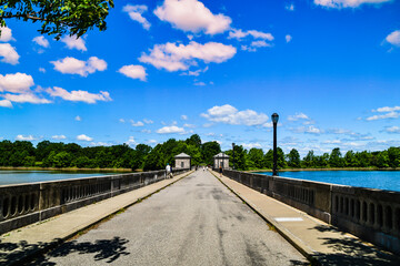 Landscape shot of Reservoir road with pump houses and blue sky along water.