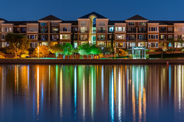 The multi-hued lights of stylish condos reflect off the calm waters of Tempe Town Lake in Arizona.