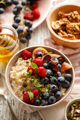 Oatmeal with fruit in a ceramic bowl - healthy and nutritious breakfast, top view