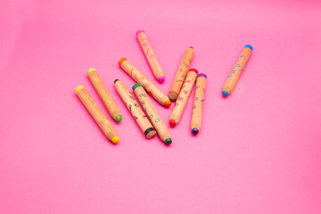 Several colorful wooden crayons isolated on pink background with copy space Colored drawing pencils for kids