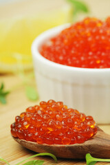 A small ceramic bowl with red caviar