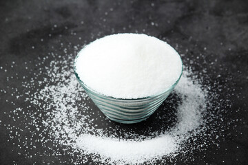 A glass bowl with white sugar