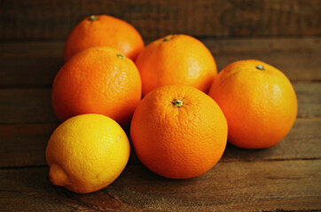 A few oranges and a lemon on wood