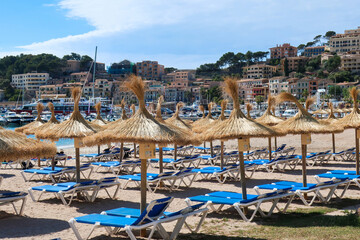 Fototapeta na wymiar Ratan umbrellas on beach in Port de Soller, Mallorca
